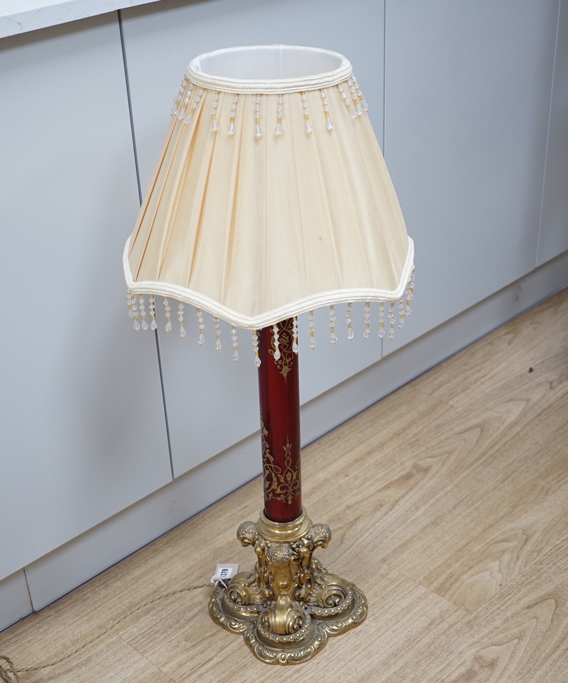 A Victorian style brass and ruby glass table lamp with shade, 81cm